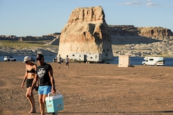 (Bethany Baker | The Salt Lake Tribune) People walk along Lone Rock Beach in Glen Canyon National Recreation Area near Page, Ariz. on Wednesday, July 12, 2023. Congress voted to undo a Biden-era rule limiting off-road vehicle use in the area. 